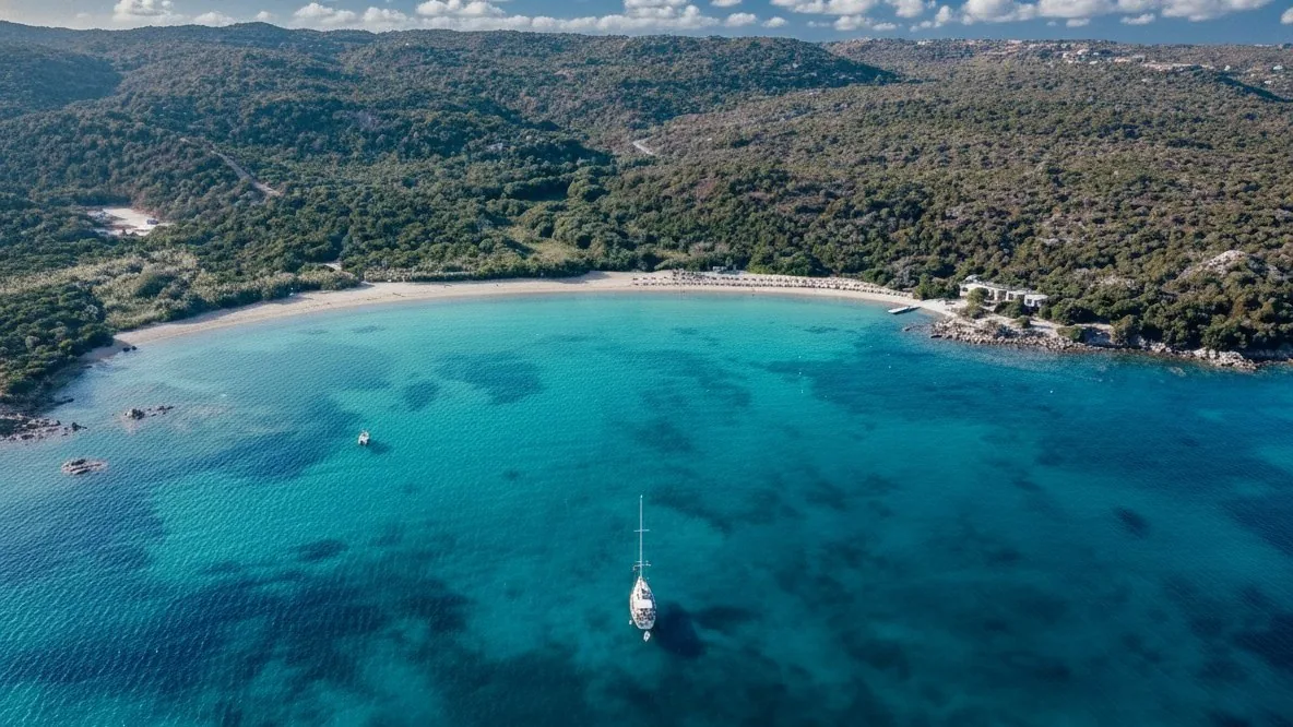 Una baia della Costa Smeralda vista dall'alto: mare color smeraldo, spiaggia chiara e macchia mediterranea